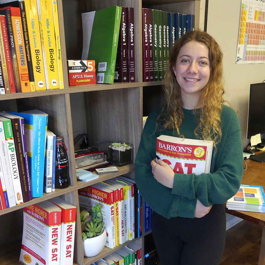 A female student holding a SAT test preparation book