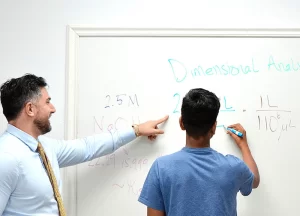 Teacher guiding students in a college prep classroom
