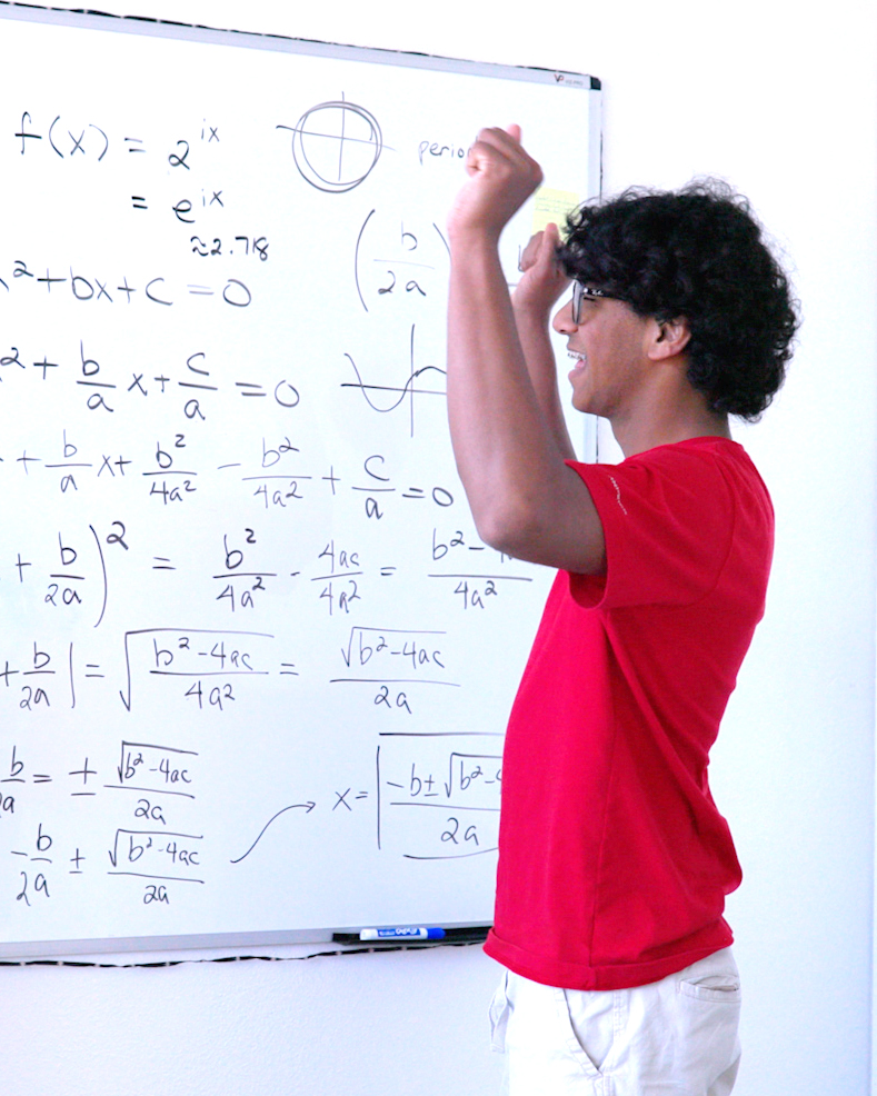 boy in red shirt cheering at whiteboard